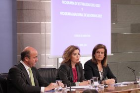 Los Ministros Luis de Guindos y Fátima Báñez, con la Vicepresidenta del Gobierno, Soraya Sáenz de Santamaría, en rueda de prensa.